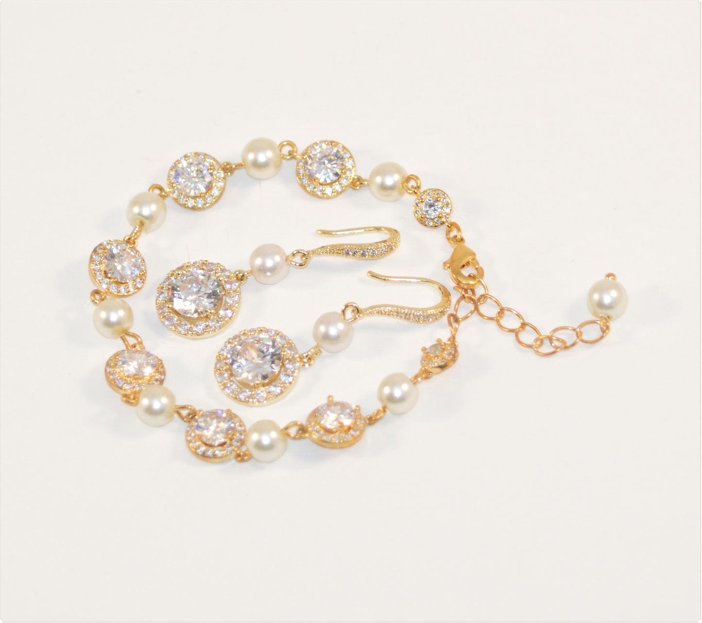 An ivory pearl bridal bracelet and earring set with gold plating and cubic zirconia stones.