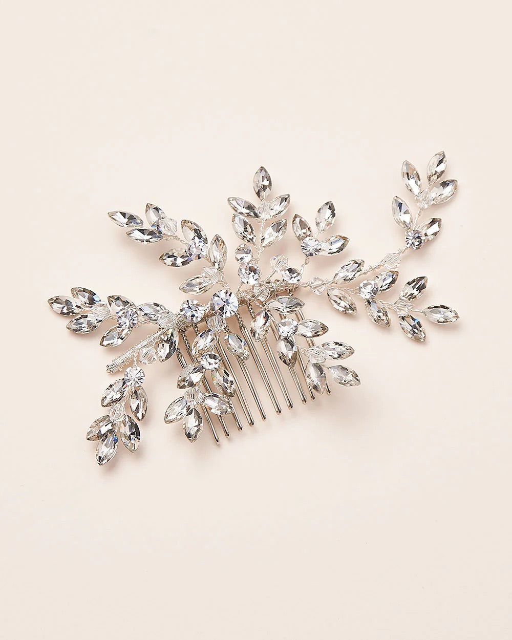 A silver metal hair comb featuring a floral design with embedded crystal gemstones, intended as a bridal accessory.