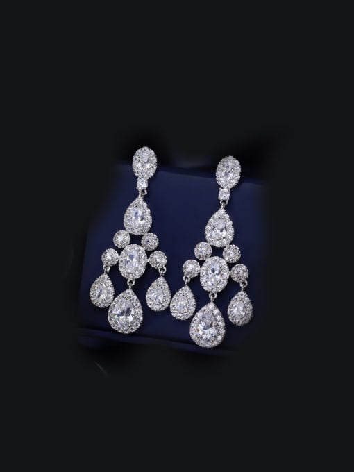A pair of silver-colored bridal earrings with teardrop and pavé stones, displayed on a mannequin.