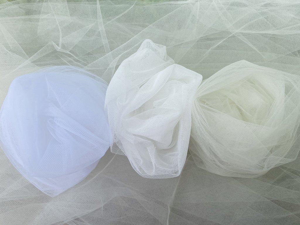 Tulle fabric shaped in circles in a row and in white, off white and cream colors.