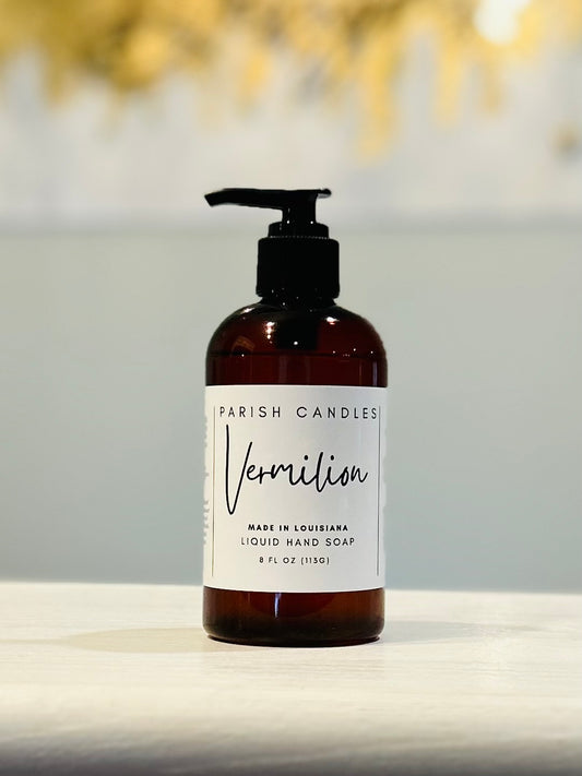A pump bottle of liquid hand soap labeled 'Parish Candles' in a brown plastic bottle with a white label in Vermilion scent, 8 ounces