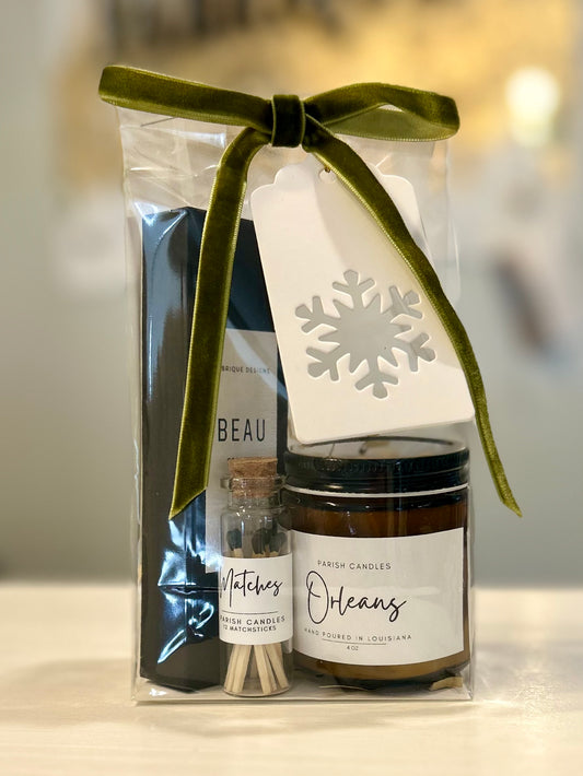 Orleans candle with matches and mini travel “Beau” cologne in a clear bag on a shelf