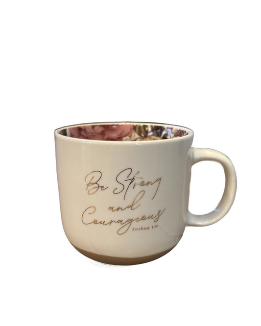 Beige mug with floral interior and 'Be Strong and Courageous' text on a white background
