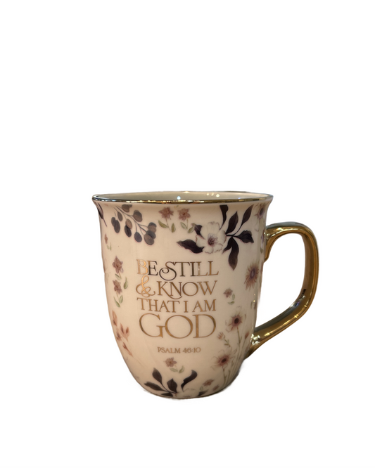 Mug with floral design and text “Be still and know that I am God” on a white background