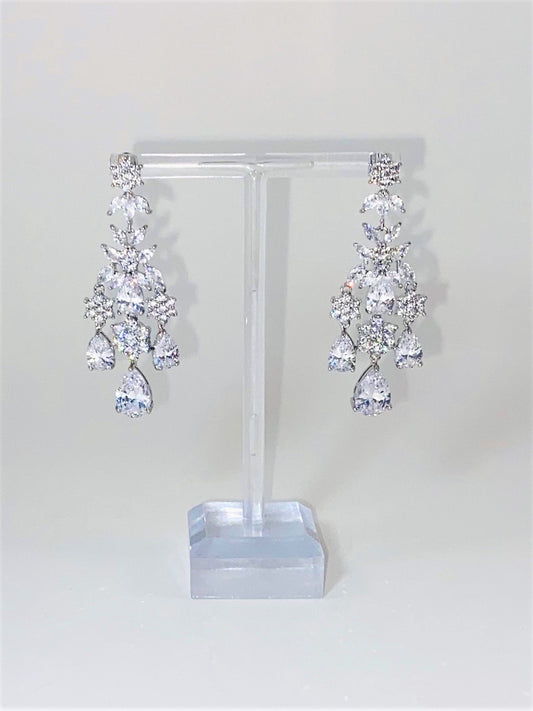 A pair of silver bridal earrings with teardrop and marquis cubic zirconia rhinestones, displayed on a mannequin.
