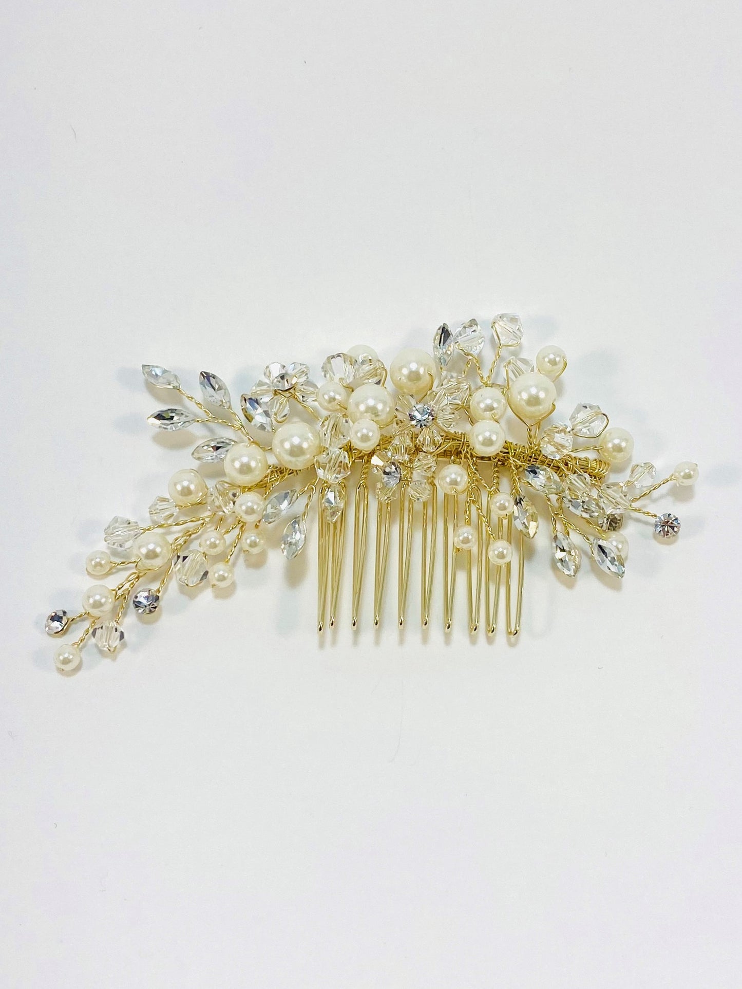 A gold-colored bridal hair comb adorned with off-white pearls, crystal beads, and gemstones.