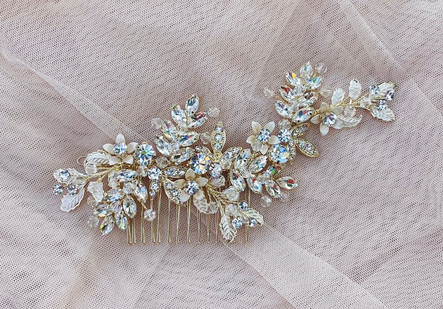 A gold bridal hair comb adorned with crystal gemstones and beads, featuring a floral design with a metal comb attachment at the back.