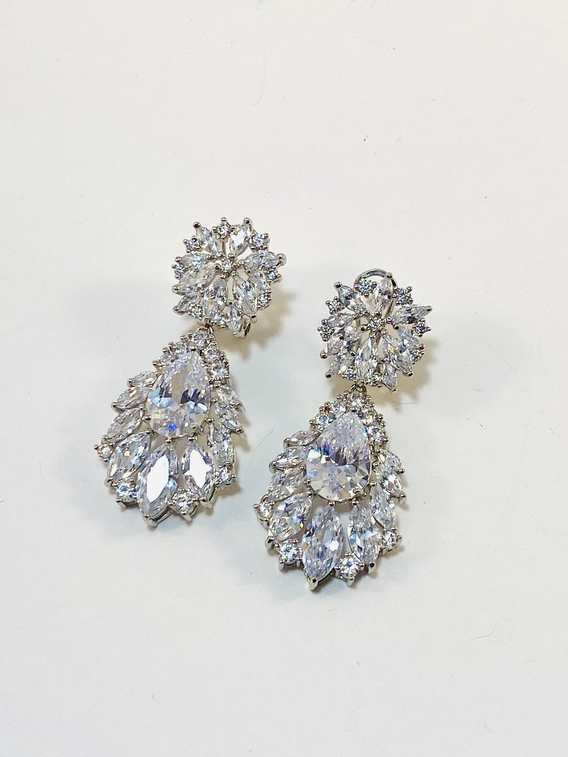 A pair of square-shaped, silver-colored bridal earrings with clear cubic zirconia stones.
