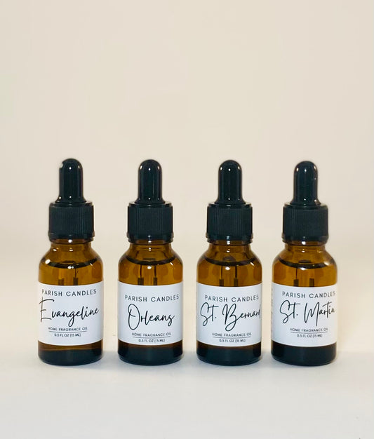 Four amber glass bottles with black dropper lids, labeled as Parish Candles home fragrance oils. Evangeline, Orleans, St Bernard and St Martin are written on the labels.