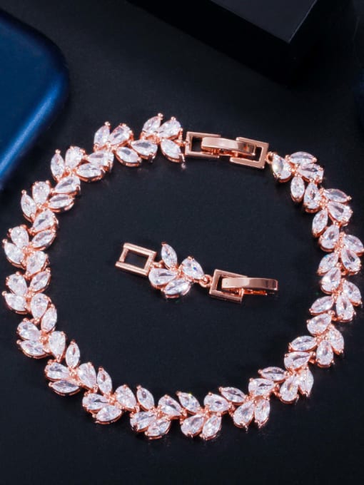 A bridal bracelet featuring a series of cascading marquis and teardrop-shaped clear crystals, with a metallic clasp in a rose gold color.